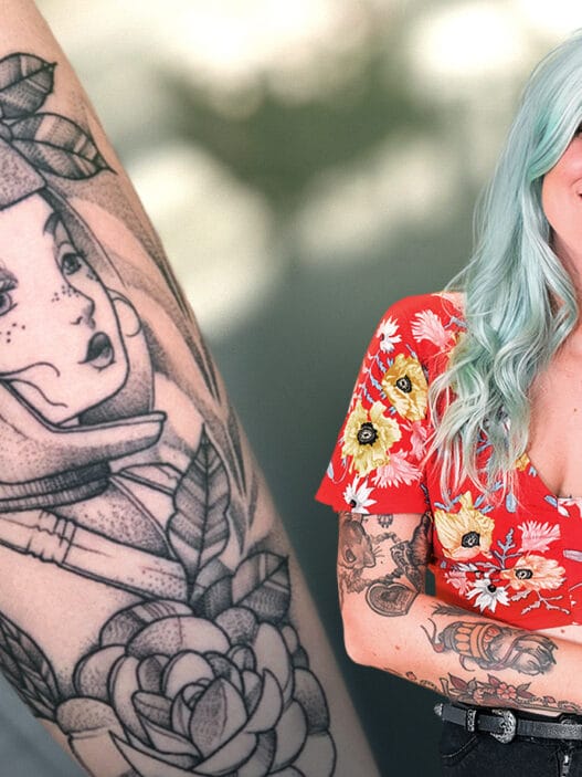 A smiling woman with light blue hair and tattoos, wearing a red floral top, stands next to a close-up of a black-and-white tattoo featuring a futuristic helmeted woman surrounded by flowers—perfect inspiration for courses online in tattoo artistry.