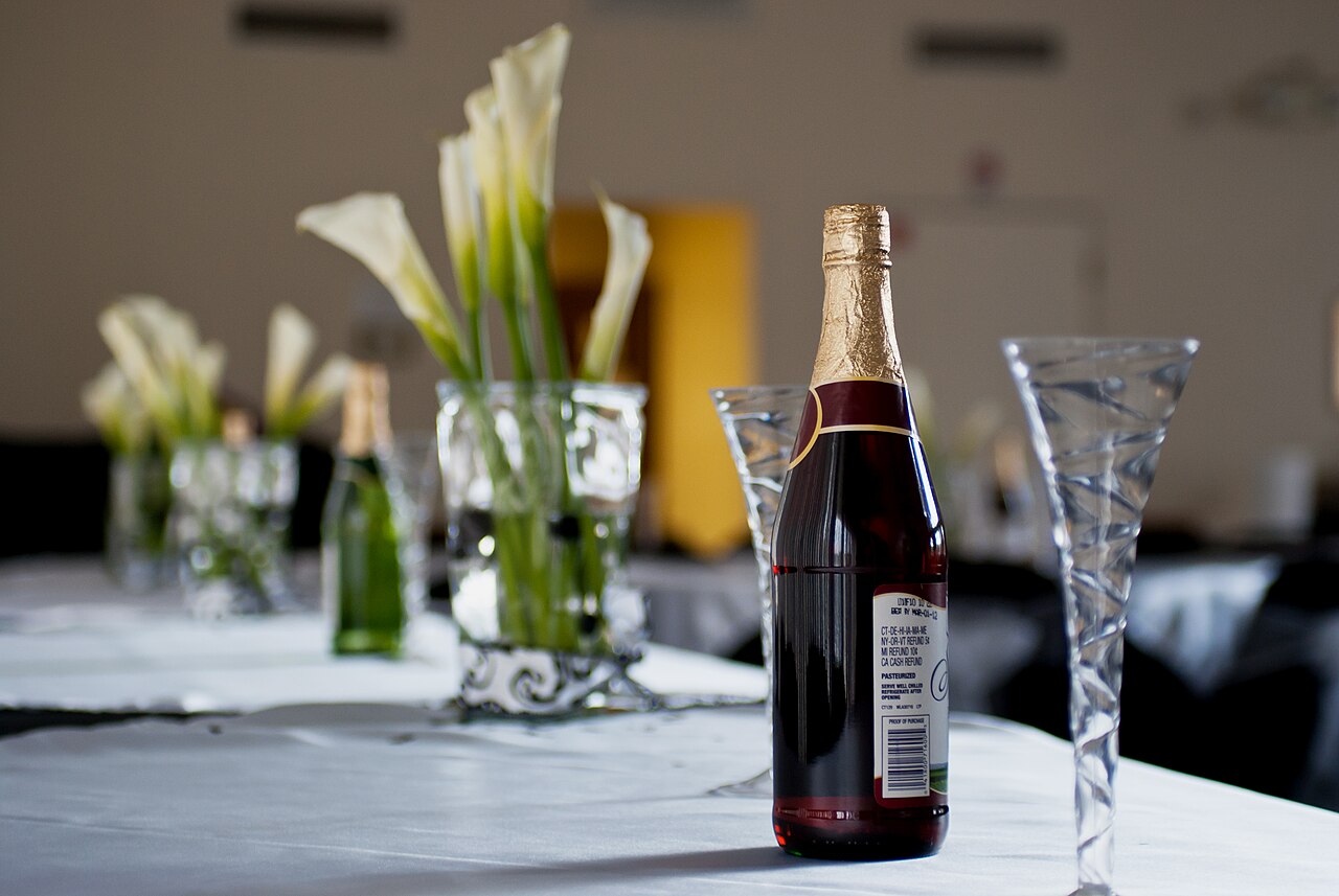 Elegantly set wedding reception table with glassware, candles, and floral details arranged by an event planner