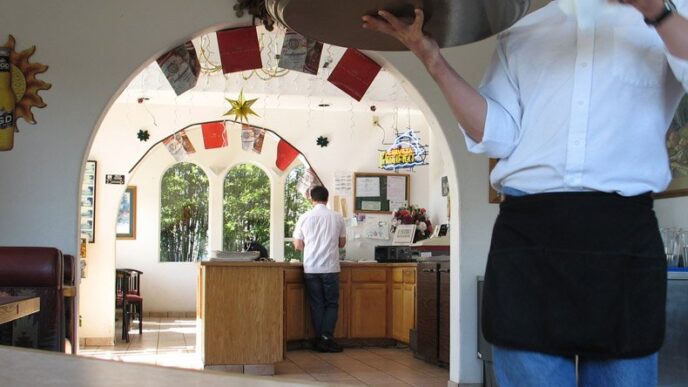 Waiter carrying a tray in a busy restaurant
