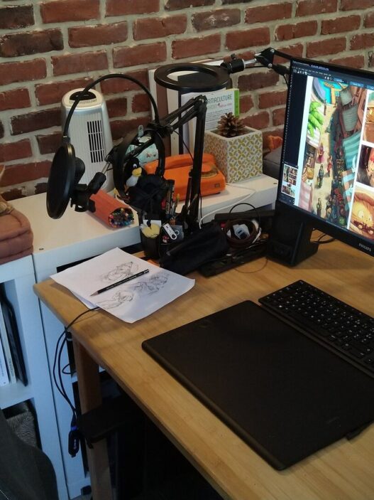 Digital artist workspace with a drawing tablet and comic artwork on screen