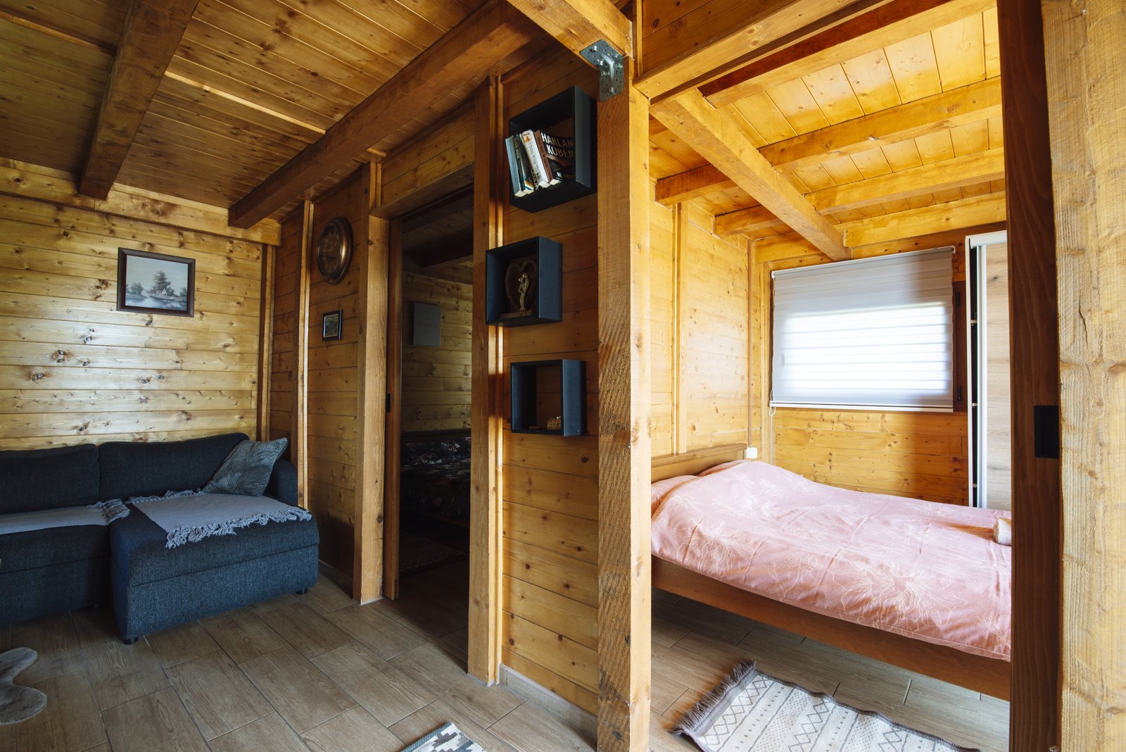 Cozy wooden cabin interior with seating area and bedroom space