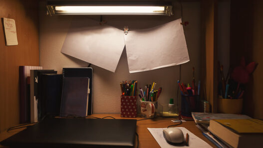 Person studying on a laptop at a small home desk