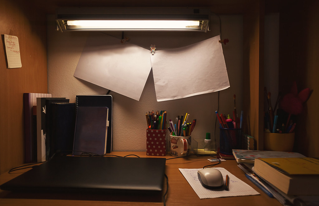 Person studying on a laptop at a small home desk