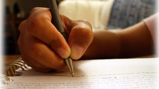 Hand writing with a pen in a spiral notebook