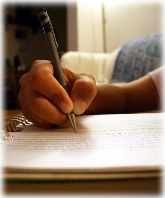 Hand writing with a pen in a spiral notebook