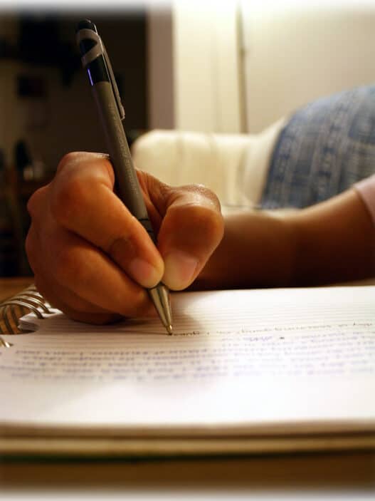Hand writing with a pen in a spiral notebook