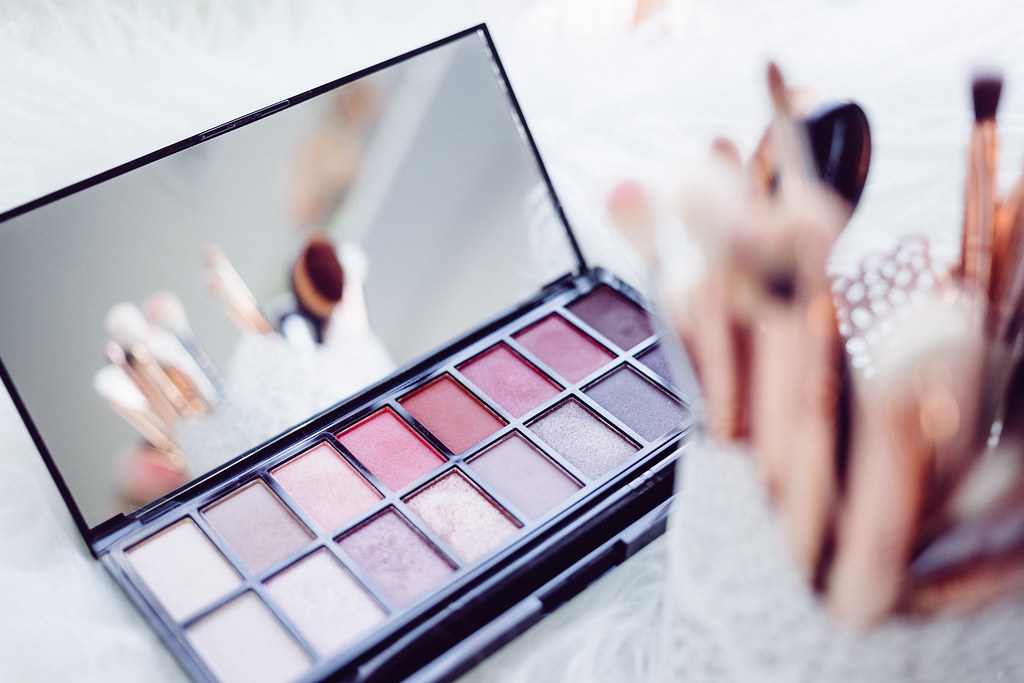 Professional makeup brushes and eyeshadow palettes arranged as an artist kit