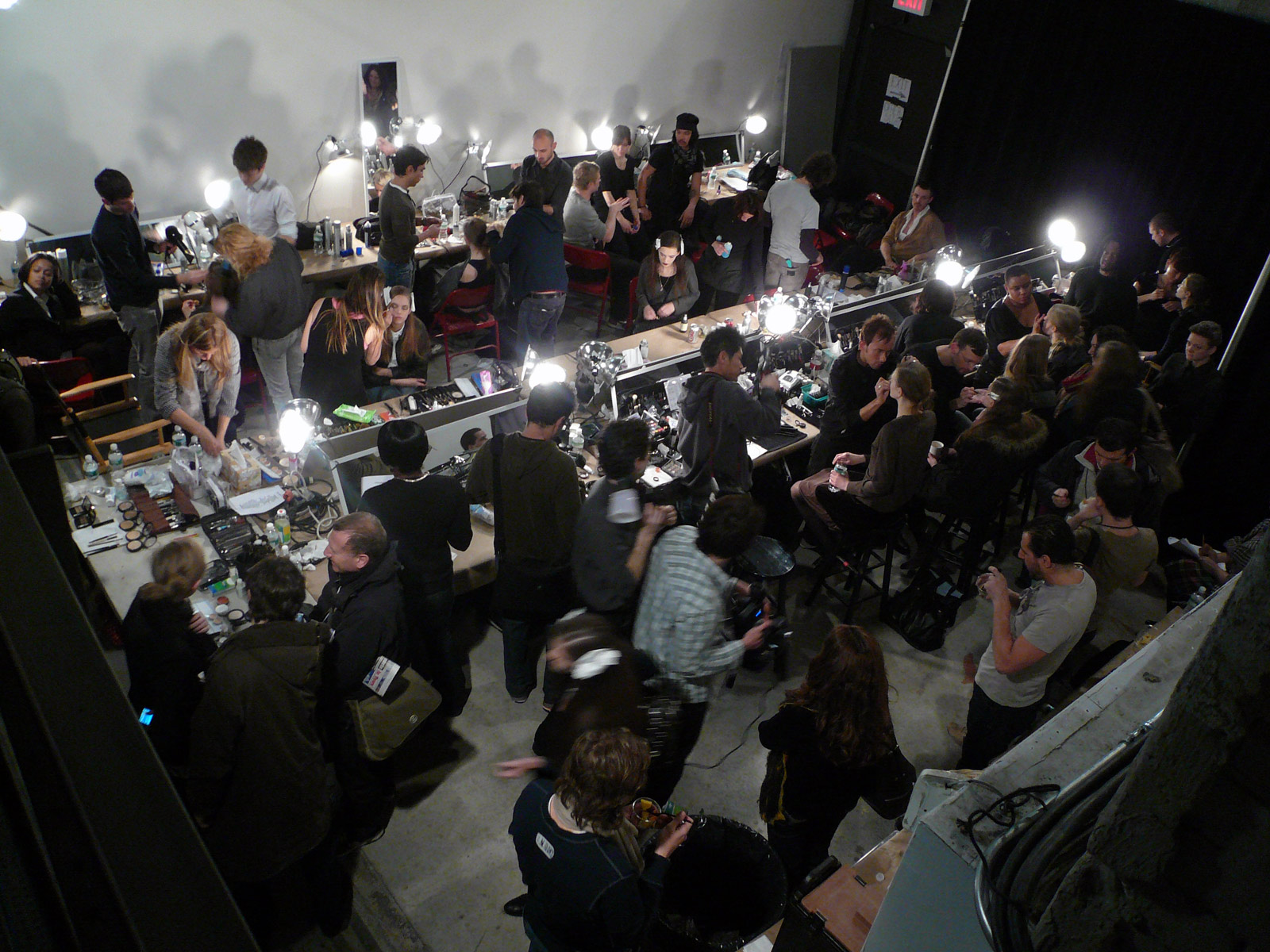 Backstage at a fashion show where makeup artists prepare models