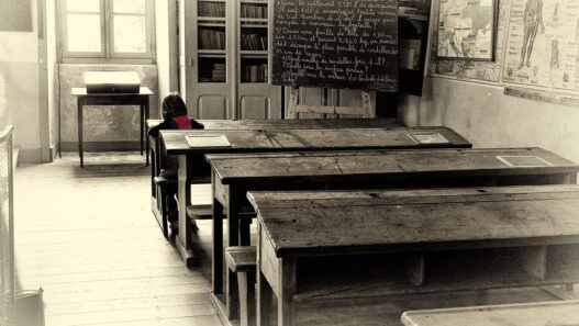 Lone student studying at a desk in a classroom
