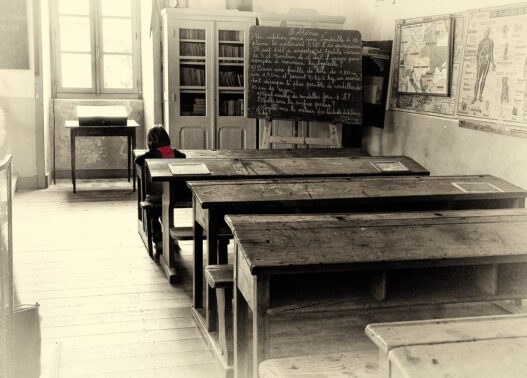 Lone student studying at a desk in a classroom