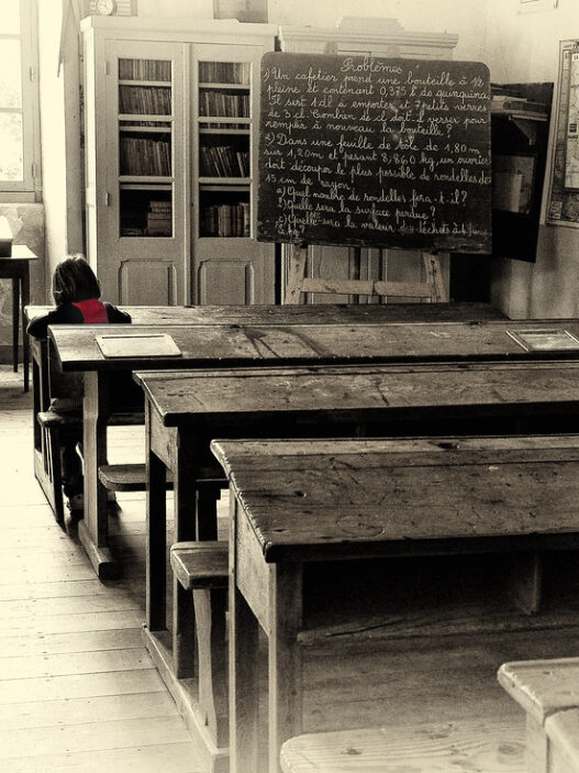 Lone student studying at a desk in a classroom