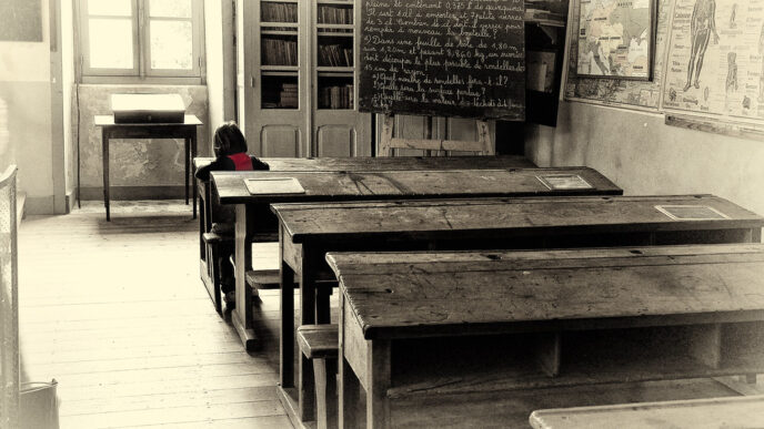 Lone student studying at a desk in a classroom