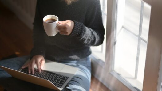 Woman freelancer working on a laptop with coffee