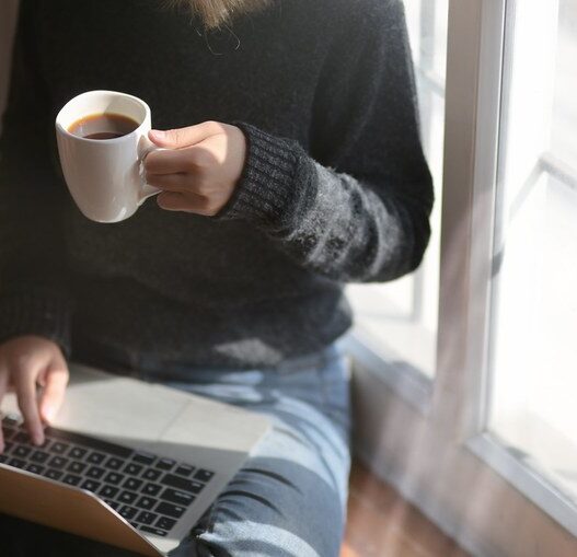 Woman freelancer working on a laptop with coffee