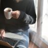 Woman freelancer working on a laptop with coffee