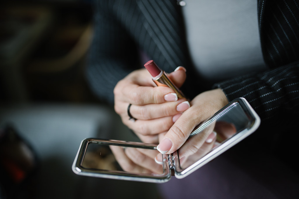 Woman looking into a handheld mirror