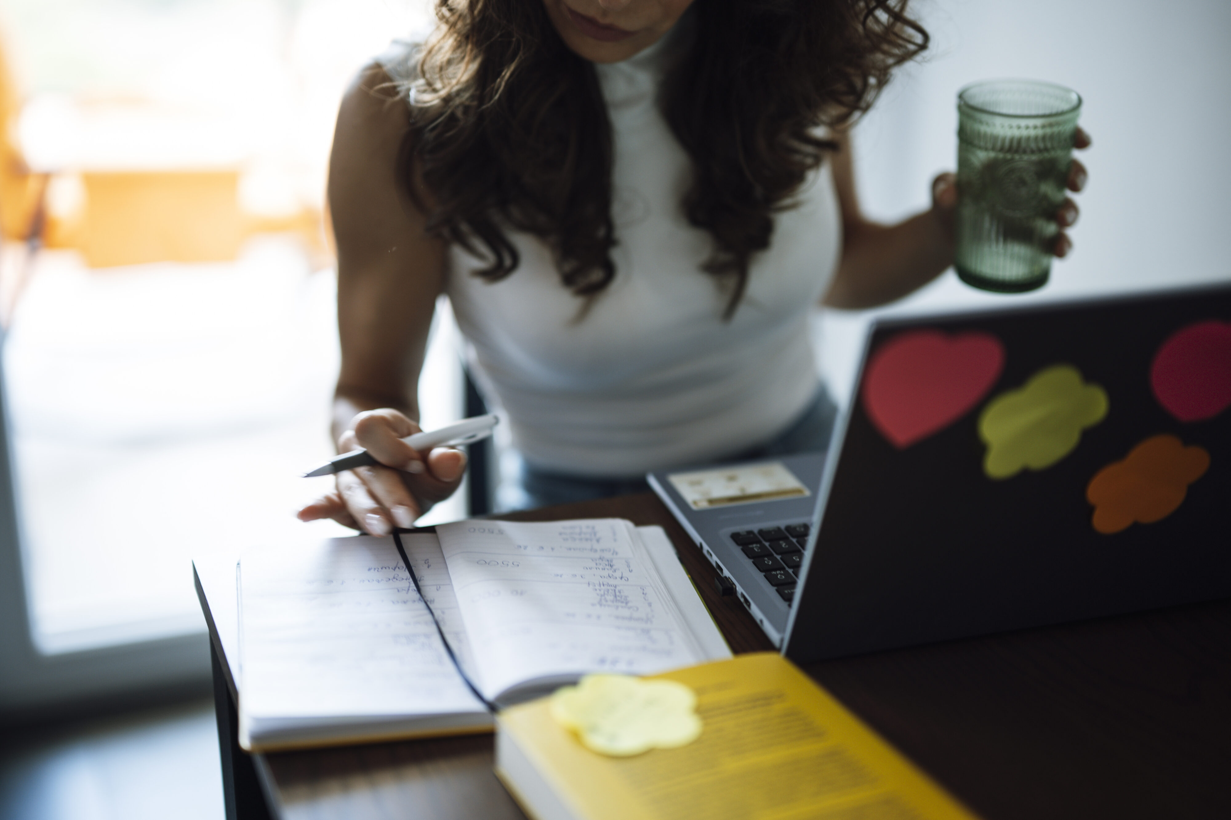 Woman studying at a desk with laptop and notebook