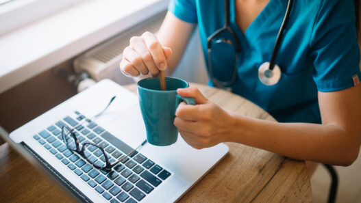 Person working on a laptop with coffee