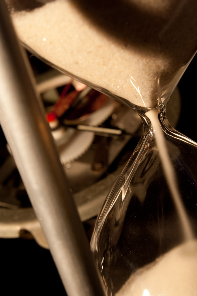 Close-up of sand flowing through an hourglass