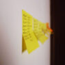 Yellow sticky notes with handwritten tasks on a wall