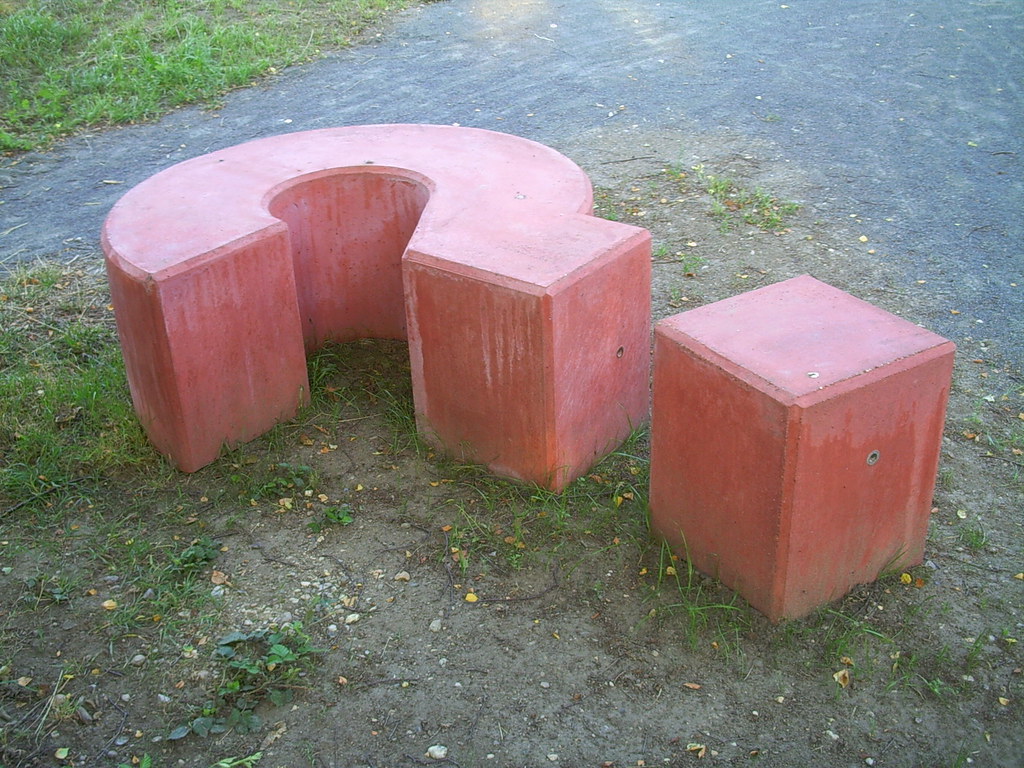 A giant concrete question mark sculpture outdoors
