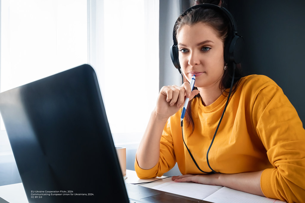 Woman with headphones studying at a laptop