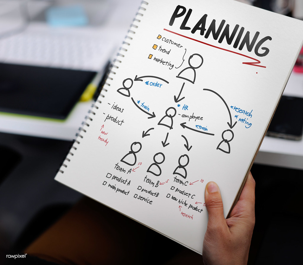 Hand holding a notebook with a planning sketch