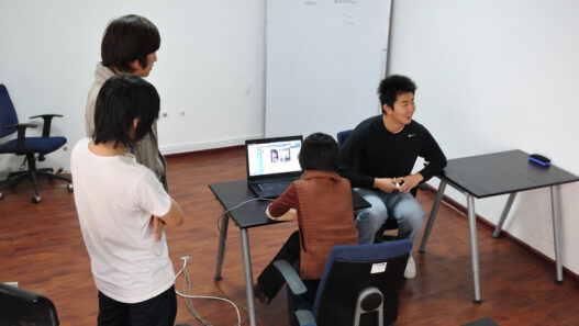 Colleagues on a video conference call, visible on a laptop screen