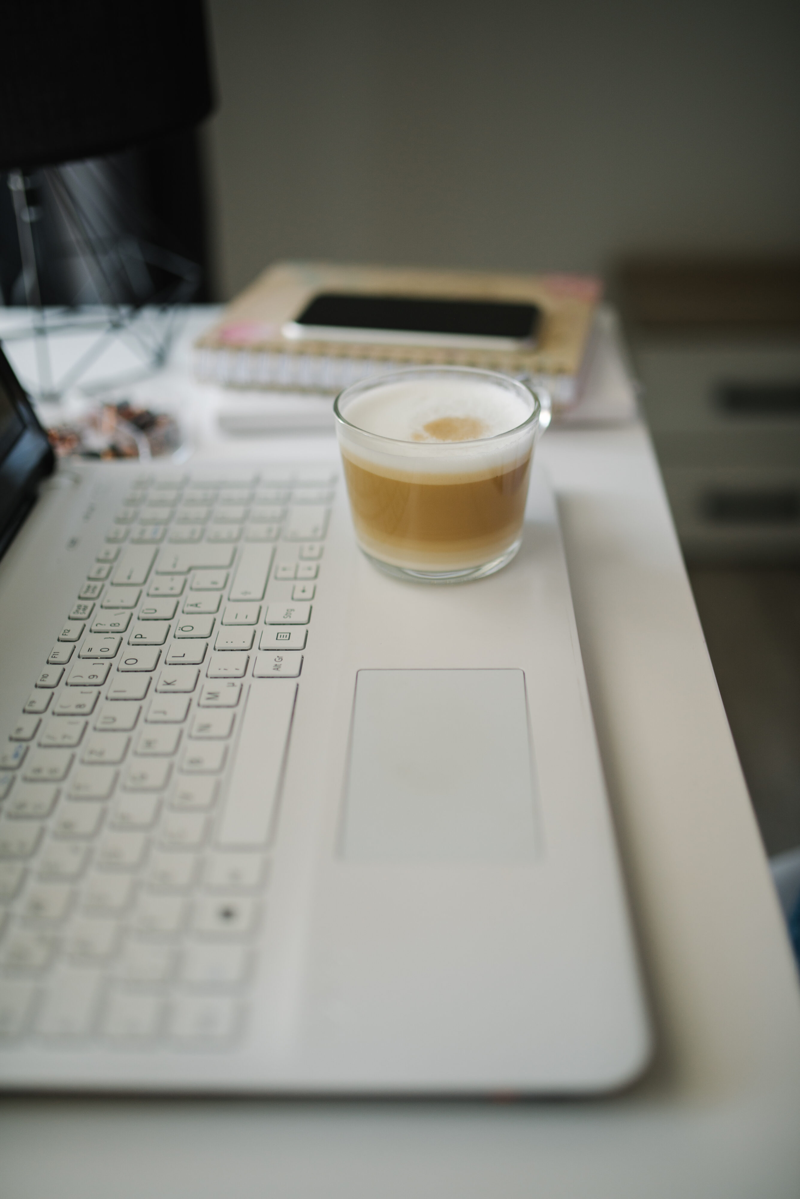 A tidy desk with coffee and a laptop set up for a morning study session