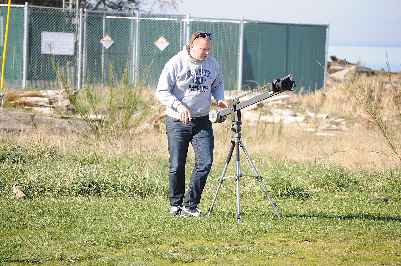 A videographer filming with a professional camera on a tripod, representing Udemy course creators