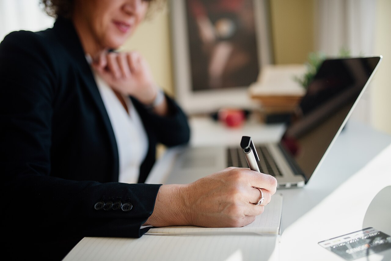 Business professional taking notes at a modern office desk