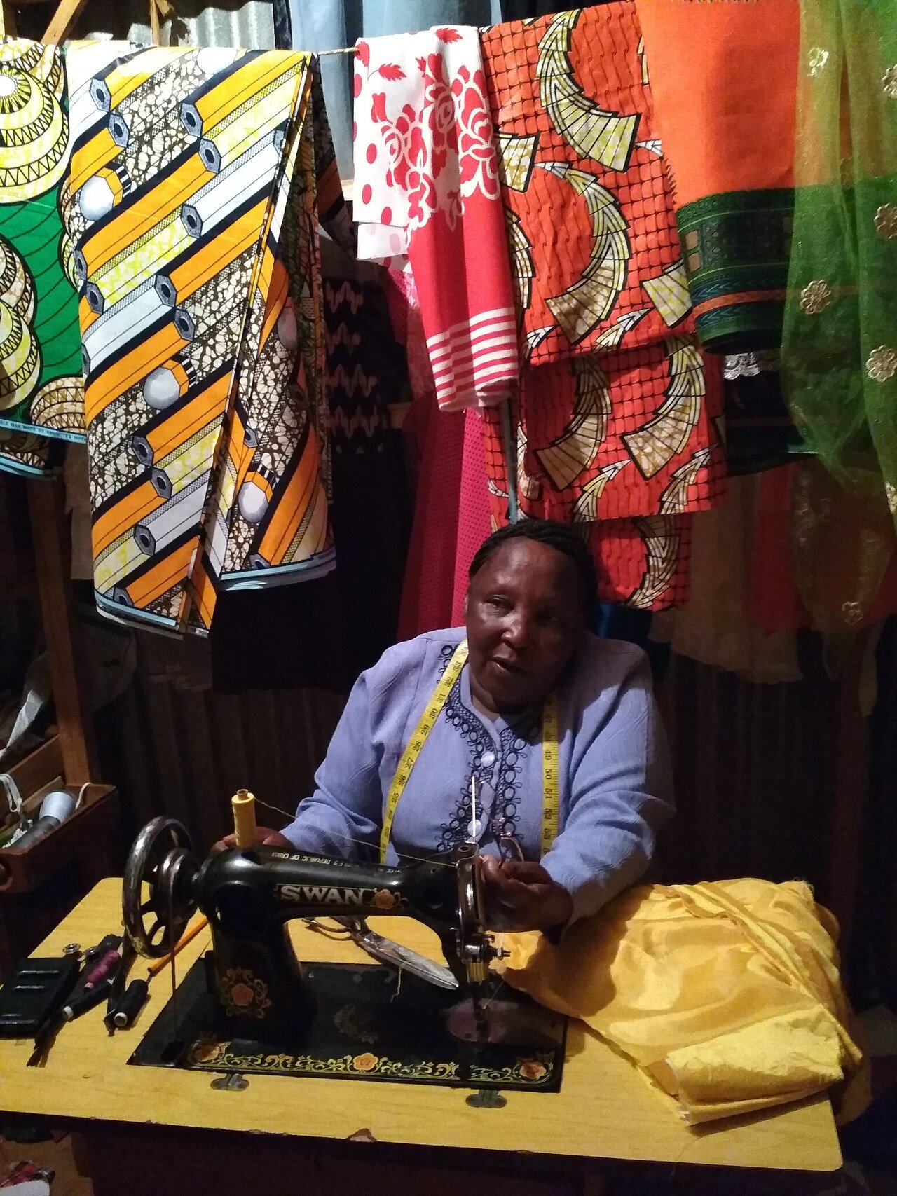 A tailor at work in her sewing workshop