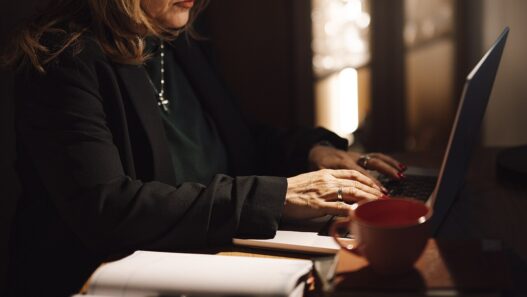 Businesswoman typing on a laptop at her home office desk