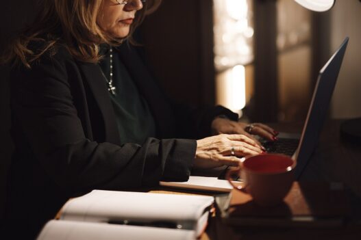 Businesswoman typing on a laptop at her home office desk