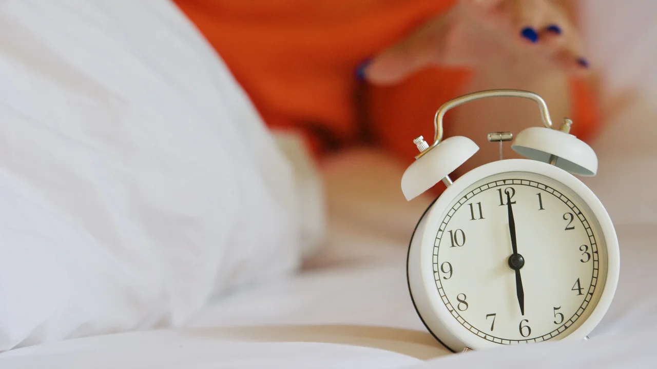 Close-up of clock on bed at home
