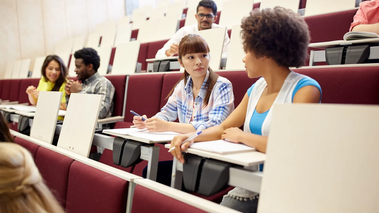 Education, high school, university, learning and people concept - group of international students talking on lecture