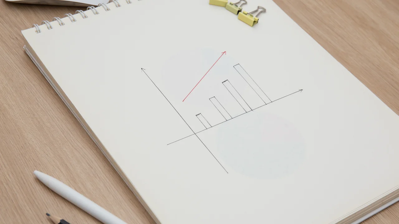 Drawing a graph of growth in a notebook on your desk at home.wooden work table