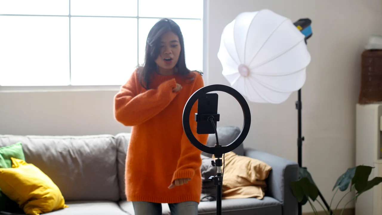 Asian woman filming video dancing challenge for social media app network using mobile phone