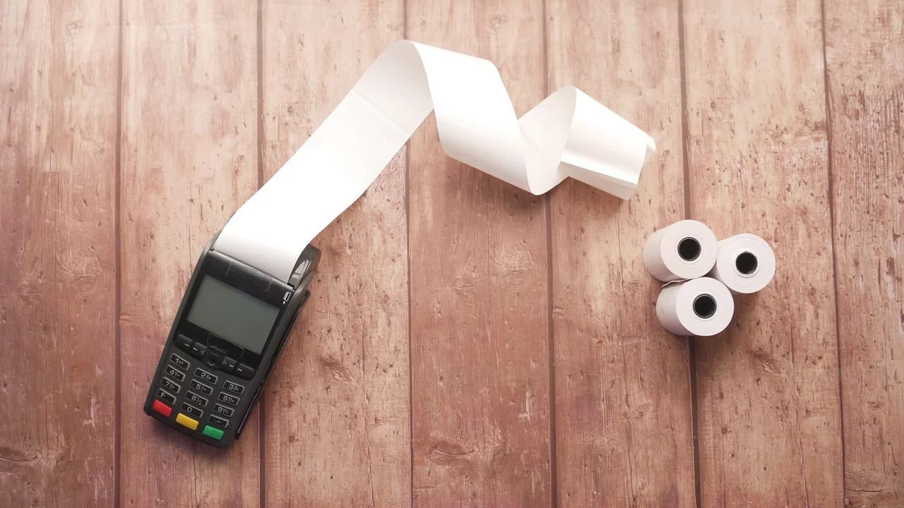 Pos machine and long roll paper on table