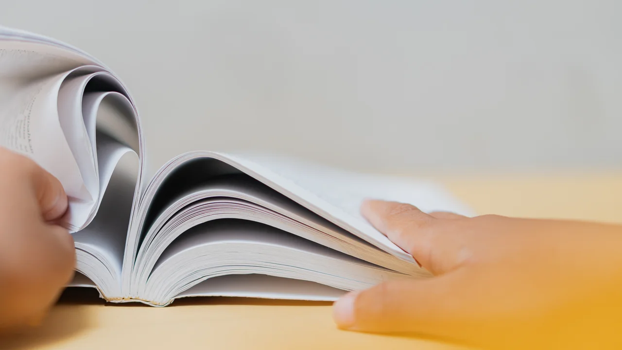 Closeup of hands flipping pages of an open book